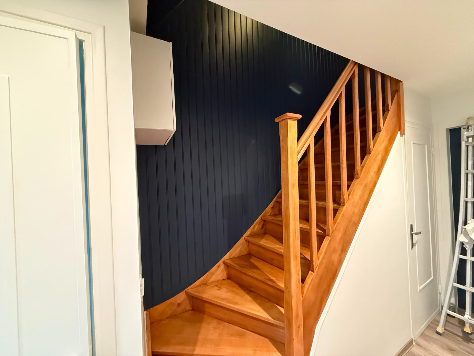Cage d'escalier — lambris peint en bleu nuit et escalier bois, après travaux