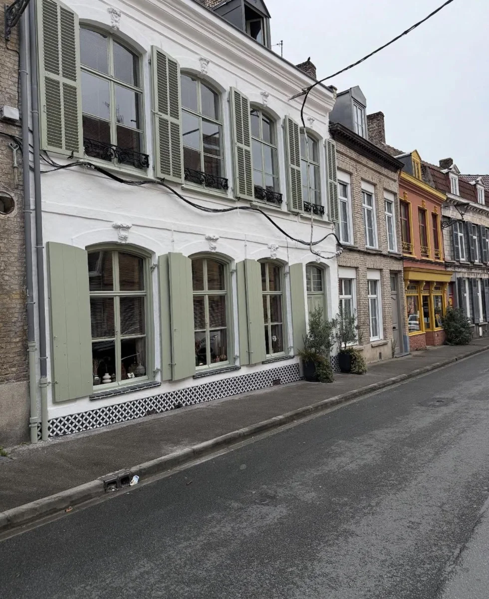 Façade de maison flamande — enduit blanc et volets vert amande, après travaux