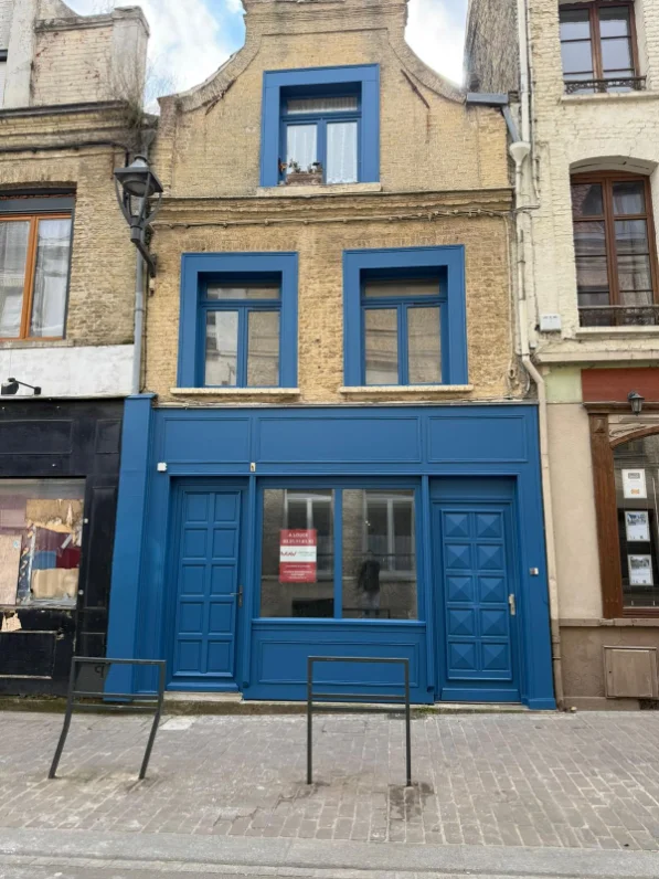 Devanture de commerce — boiseries et menuiseries repeintes en bleu profond, après travaux